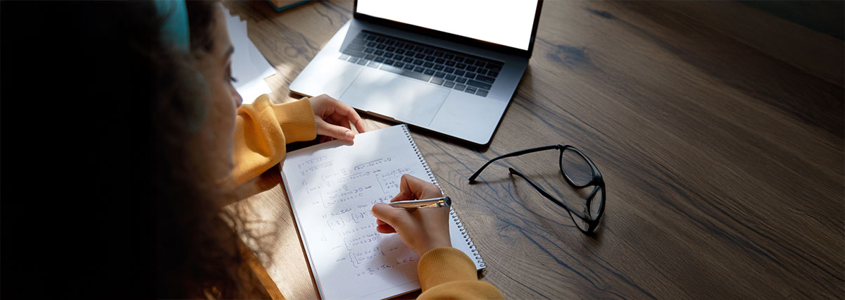 Students studying with past exam papers and study materials